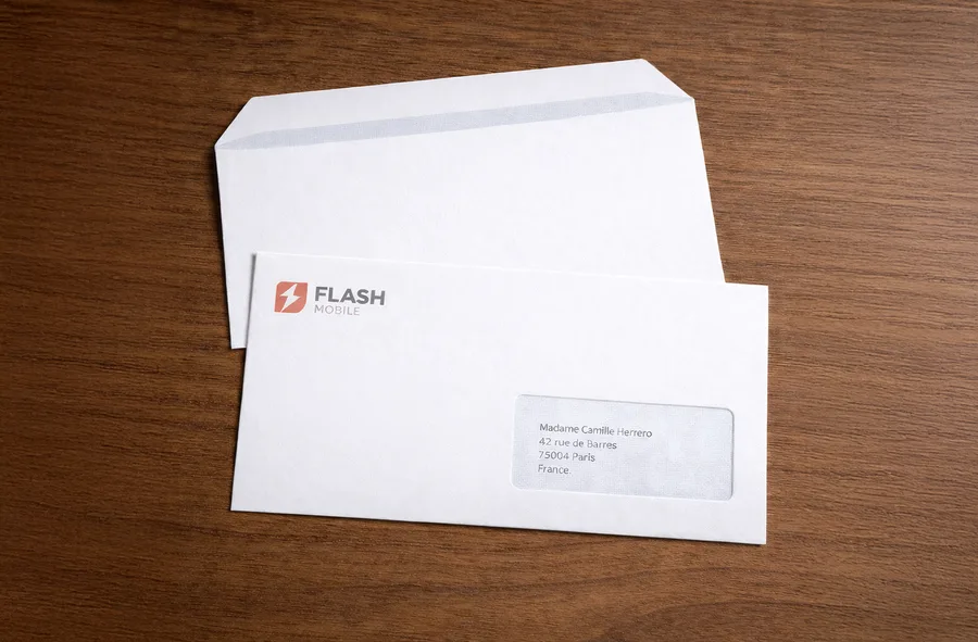 Enveloppe DL blanche avec logo de l'expéditeur en haut à gauche et adresse du destinataire visible dans la fenêtre en bas à droite