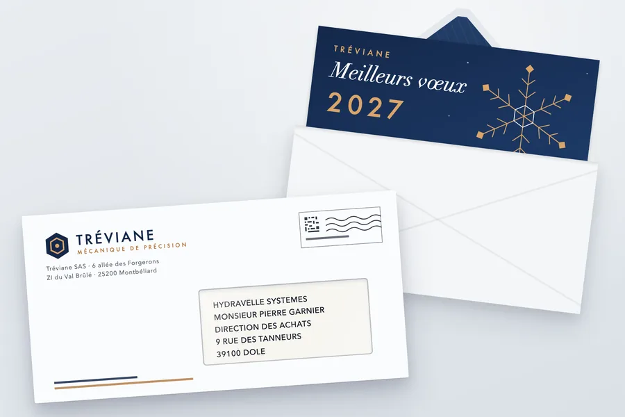 Enveloppe DL blanche imprimée au logo d'une PME industrielle fictive, logo et expéditeur en haut à gauche, affranchissement en haut à droite, fenêtre à droite laissant voir l'adresse ; derrière, une seconde enveloppe ouverte d'où dépasse la carte de vœux 2027